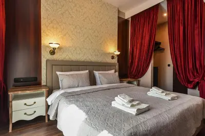 a bedroom with a large bed with red curtains at Palace of Culture 2-Bedroom Retreat on Skobelev blvd in Sofia