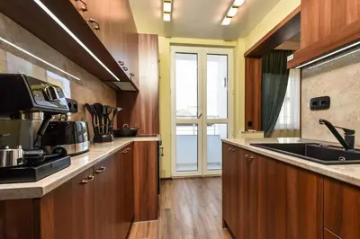 a kitchen with wooden cabinets and a sink at Palace of Culture 2-Bedroom Retreat on Skobelev blvd in Sofia