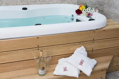 a bath tub with towels and a glass of wine at Zlaten Rozhen Family Hotel- Monument of Cultural Significance in Rozhen