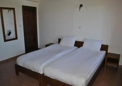 a bedroom with a large bed with white sheets at Хотел Планински кът in Dorkovo