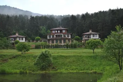 a large house in the middle of a field at Хотел Планински кът in Dorkovo