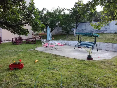 a yard with a playground with a bench and an umbrella at Hadjibulevata Guest House in Kovachevtsi