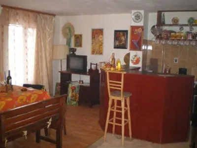 a living room with a kitchen and a bar at Hadjibulevata Guest House in Kovachevtsi