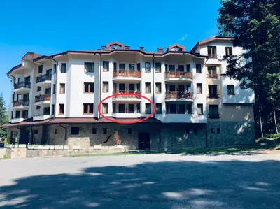 a large white building with a red circle on it at Studio Villa Park Premium in Borovets