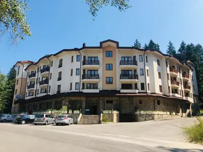 a large building with cars parked in a parking lot at Studio Villa Park Premium in Borovets