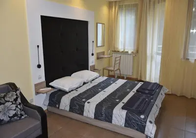 a bedroom with a large bed and a couch at Studio Villa Park Premium in Borovets