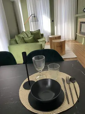 a table with a black plate and two wine glasses at Luxury Green Apartment - up to 4 people in Bansko