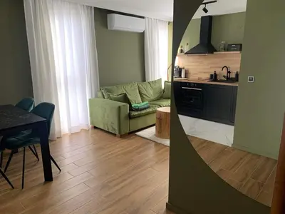 a kitchen and a living room with a couch and a table at Luxury Green Apartment - up to 4 people in Bansko