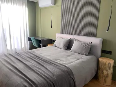 a bedroom with a large bed and a desk at Luxury Green Apartment - up to 4 people in Bansko