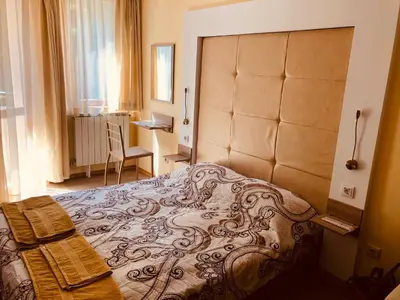 a bedroom with a large bed and a desk at Studio Villa Park Premium Gold in Borovets