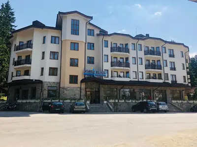 a large building with cars parked in a parking lot at Studio Villa Park Premium Gold in Borovets