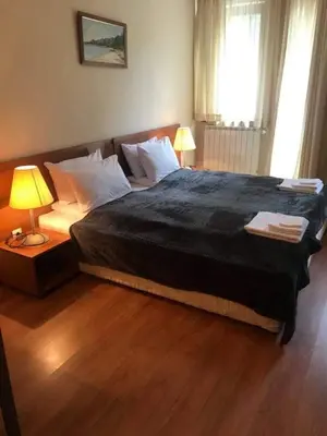 a bedroom with a large bed with a black comforter at Studios -Villa Park SV in Borovets
