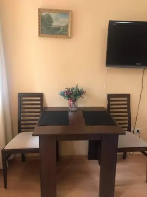a dining room table with two chairs and a television at Studios -Villa Park SV in Borovets