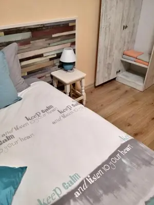 a bedroom with a bed and a table with a lamp at Апартамент Allegri Padrini Комплекс Вели Хилс in Velingrad