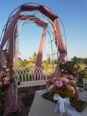 a wedding arch with a bunch of flowers on a table at Апартаментен туристически комплекс Аква Терми in Krasnovo