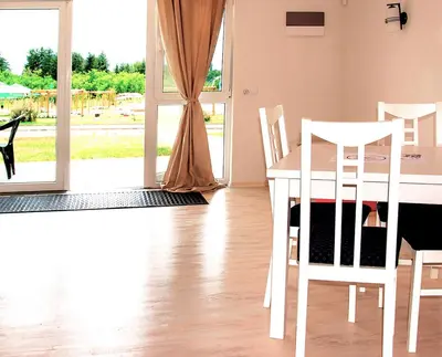 a dining room with a table and chairs and a window at Апартаментен туристически комплекс Аква Терми in Krasnovo