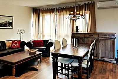 a living room with a table and a couch at Charming apartment in the heart of Bansko in Bansko