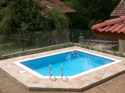 a large swimming pool in a yard with a fence at Villa Nanevi in Teteven