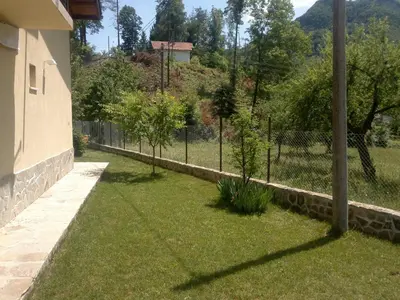 a garden with a fence and trees in a yard at Villa Nanevi in Teteven