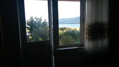 an open door with a view of a lake at Айрови in Sarnitsa