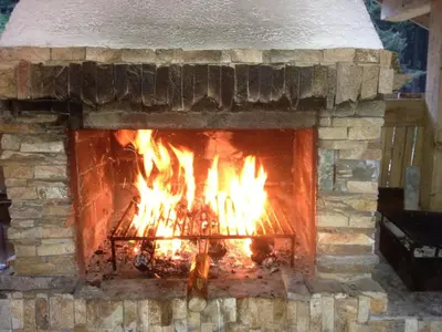 a brick fireplace with a fire in it at Ski Apartment in Castle Complex in Pamporovo
