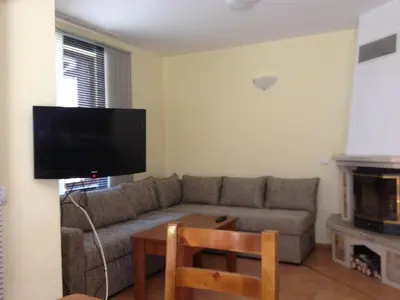 a living room with a couch and a tv at Ski Apartment in Castle Complex in Pamporovo