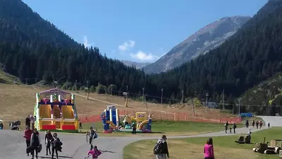 a group of people walking around a playground at Apartman u kompleksu Royal Towers in Bansko