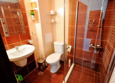 a bathroom with a toilet and a sink and a shower at Apartman u kompleksu Royal Towers in Bansko