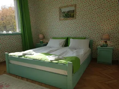 a bedroom with a green bed with two night stands at Casa Vivaldi in Velingrad