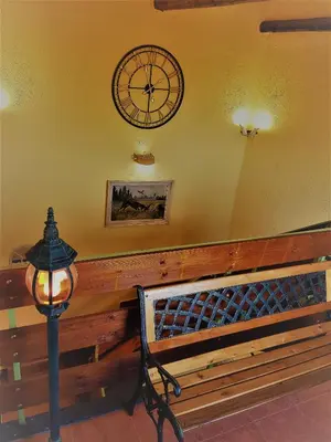 a clock on the wall next to a bench at Casa Vivaldi in Velingrad