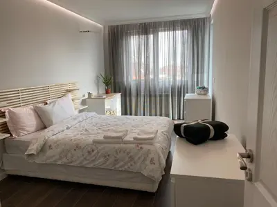 a bedroom with a large bed and a window at Apartment The Orchid in Sofia