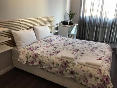 a bedroom with a large bed with a floral blanket at Apartment The Orchid in Sofia