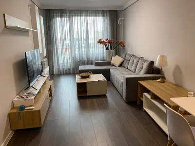 a living room with a couch and a tv at Apartment The Orchid in Sofia
