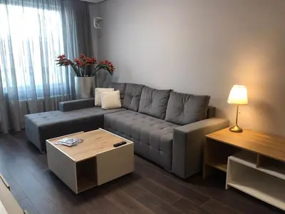 a living room with a couch and a table at Apartment The Orchid in Sofia