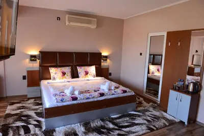 a bedroom with a large bed and a large mirror at Family Hotel Gotse Delchev in Gotse Delchev