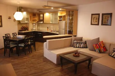 a living room with a couch and a table and a kitchen at Central Square Apartment in Plovdiv