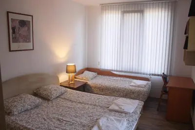 a hotel room with two beds and a window at Central Square Apartment in Plovdiv