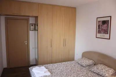a bedroom with a bed and a wooden cabinet at Central Square Apartment in Plovdiv