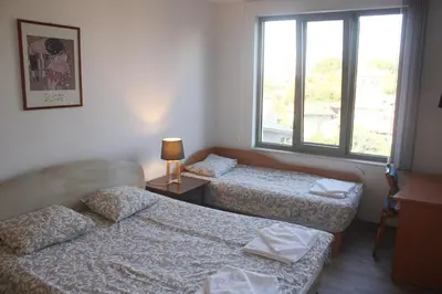 two beds in a room with a window at Central Square Apartment in Plovdiv