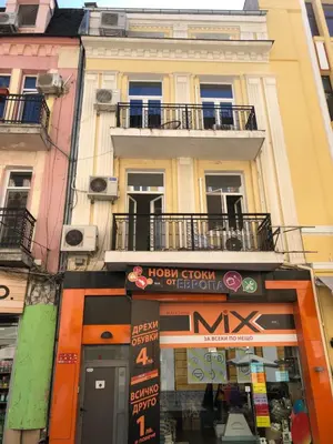 a building with a sign in front of a store at Beautiful best location apartment Red Mouse in Plovdiv
