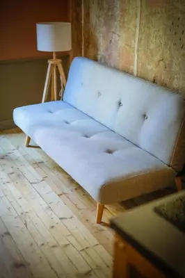 a blue couch sitting in a room with a lamp at Beautiful best location apartment Red Mouse in Plovdiv