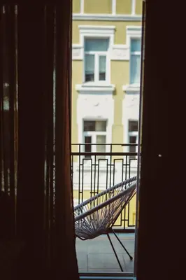 a chair sitting on a balcony looking out a window at Beautiful best location apartment Red Mouse in Plovdiv