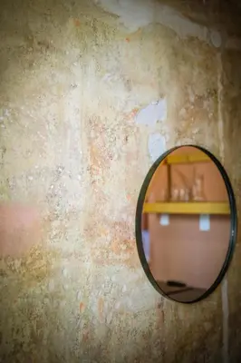 a mirror hanging on a wall with a table at Beautiful best location apartment Red Mouse in Plovdiv