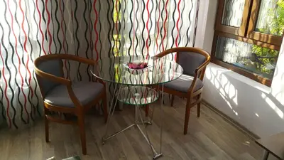 a glass table and two chairs in a room at Art House Plovdiv in Plovdiv