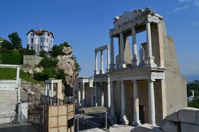 a building on a hill with a house in the background at Art House Plovdiv in Plovdiv