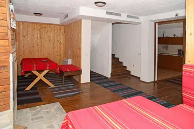 a room with a red table and a staircase at guest house Margarita in Bryagovo