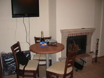 a dining room with a table and a fireplace at Cozy Studio in Mountain Lake Complex Smolyan Pamporovo in Smolyan