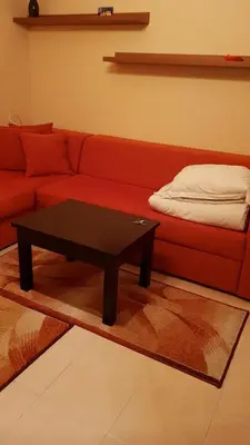 a living room with a red couch and a coffee table at Cozy Studio in Mountain Lake Complex Smolyan Pamporovo in Smolyan