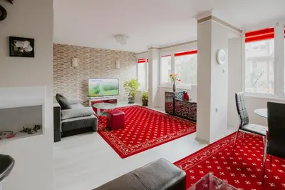 a living room with a red rug at Dimitrovi Rooms in Sofia