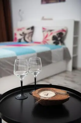 two wine glasses and a plate on a table at Business sky Loft in Sofia